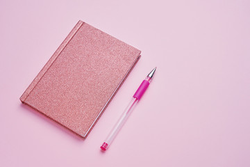 Pink notepad with pen on pastel pink backdrop. Back to school concept. Copy space, top view