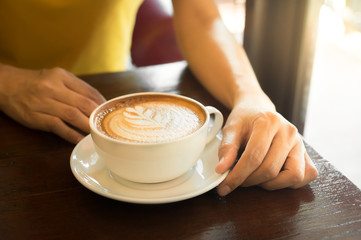 Woman holding coffee cup in hand.