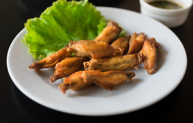 Fried chicken wings with vegetable on plate.