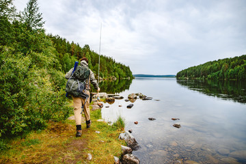 Male fisherman goes fly fishing on mountain river