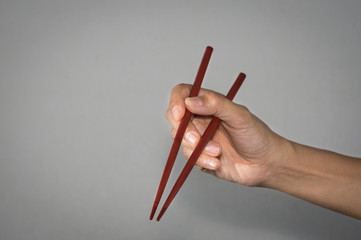 Woman wooden chopsticks in hand.
