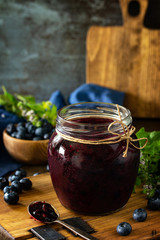 Organic Homemade Preserves. Blueberry jam in a jar and fresh blueberries on rustic wooden table. Free space for your text.