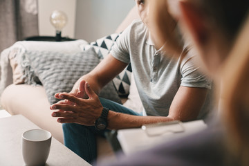 Photo cropped of thoughtful caucasian man having conversation with psychologist in room
