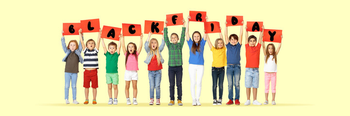 Black friday, sales concept. Group of childrens, kids and teens in bright clothing with emotions of happiness holdind letters on yellow background. Negative space. Colorful image for your ad.