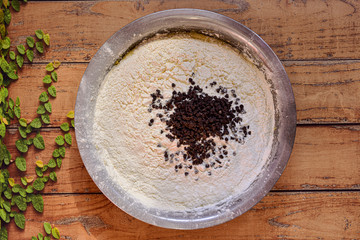 Bowl with starch (flour) and chocolate chips on wooden surface