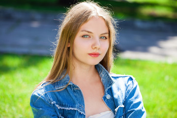 Portrait of a young beautiful girl in on summer park background