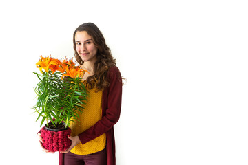 Cute young girl holding oranges lily flower bouquet and looking smiling at camera isolated on white background. Concept of happiness, girl power, pleasure, Valentine's Day, lifestyle, and love.