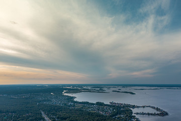 The river, countryside and far village  under amazing clouds in sunset time.