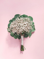 Bouquet of gypsophilia flowers isolated on light pink background. Flat lay. Top view