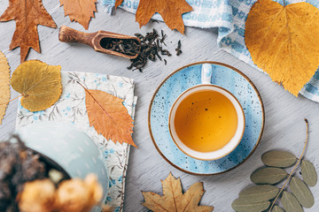 Naklejka na ściany i meble autumn warming tea on a wooden table with autumn tree leaves lying nearby