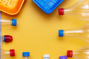 used plastic, crumpled empty bottles, packets, dish, container pollution garbage recycle eco concept yellow background close up