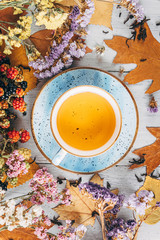 autumn warming tea on a wooden table with autumn tree leaves lying nearby