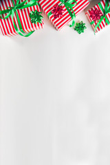 Christmas gift boxes simple pattern background. Festive boxes with Christmas presents, decorated with bright bows with ribbons. Flatlay, above copy space