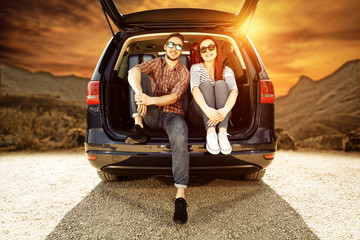 Two young people and autumn trip of car 