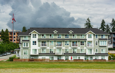 New residential low-rise building on cloudy sky background