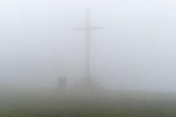 Cross with people in the fog