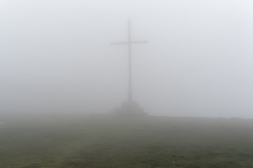 cross on the hill in the fog