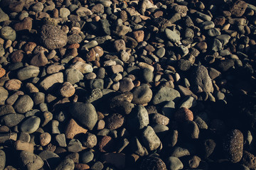 Textura piedras redondas en playa con luz del atardecer