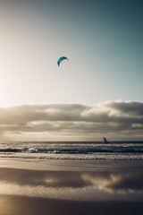 Personas practicando kitesurf al atardecer en la playa de Famara en la isla de Lanzarote