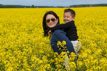 Boy with his mother in a field with yellow flowers