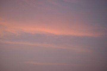 Light orange colored sky with visible clouds during a sunset