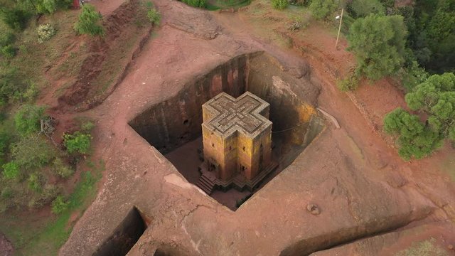 Rotating bird's eye perspective of famous Saint George rock-hewn monolithic church in Lalibela, carved downwards out of volcanic tuff, landmark destination in Ethiopia Africa