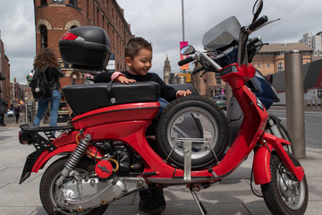 Obraz na płótnie Canvas Boy admiring a beautiful red motorbike