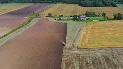 Aerial view drone of harvest field with tractor mows dry grass. Autumn yellow field with a haystack after harvest top view. Harves. Ting in the fields. 
