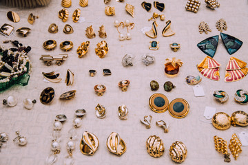 Retro earrings.Jewelry 80-90s.Gold clips.flea market.Counter with jewelry.Vintage things. Aesthetics. Fair of old things.Sale of unnecessary things.Garage sale.Weekend Market.Antiques.Second hand.