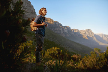 Naklejka premium Happy male tourist hiking in mountains beautiful view