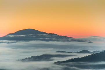 Fototapeta na wymiar Fog and complex of mountain landscape with colorful twilight.