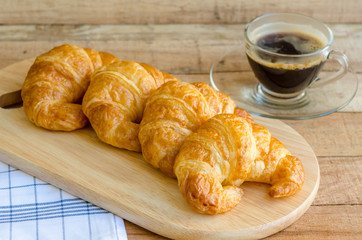 breakfast with cup of black coffee and fresh butter croissants
