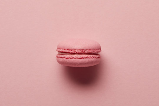 Pink French macaroon in center on pink background