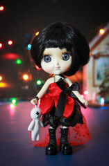 decorative ceramic monster doll with black hair and a red dress for Halloween