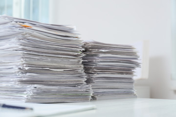 Stacks of documents on table in office