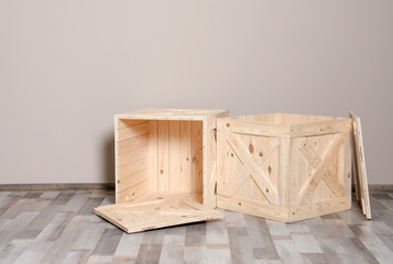 Wooden crates on floor at beige wall. Space for text