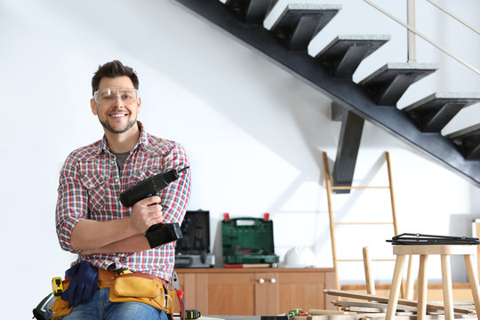 Handsome Working Man With Electric Screwdriver Indoors, Space For Text. Home Repair