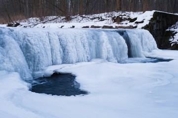 Fototapeta premium Frozen river, old water weir in winter. Ice beauty, frozen streams of water. Hluchova river, Bystrice, Czech republic.
