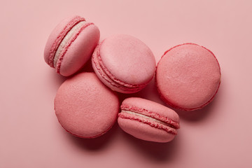 Tasty french pink macaroons with pink filling on pink background