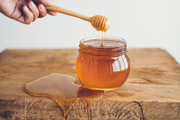 Honey in a glass and Honey scoop White background
