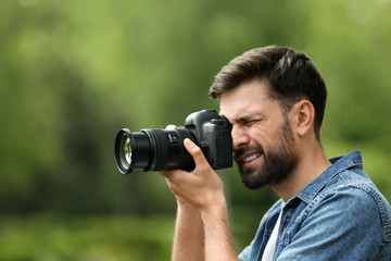 Fototapeta na wymiar Photographer taking photo with professional camera in park