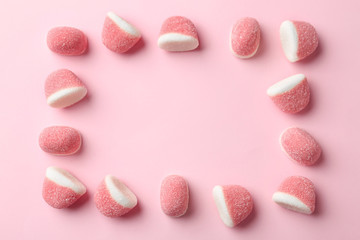 Frame of sweet jelly candies on pink background, flat lay. Space for text