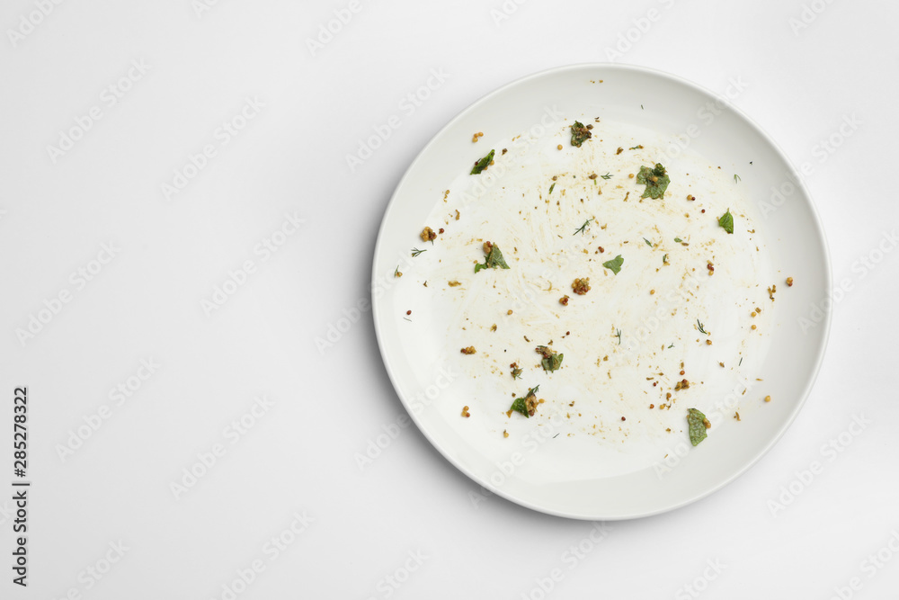 Poster Dirty plate with food leftovers on white background, top view