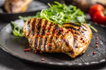 Chicken breast grilled with spices peper salt tomatoes and arugula