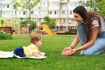 Adorable little baby crawling towards mother outdoors