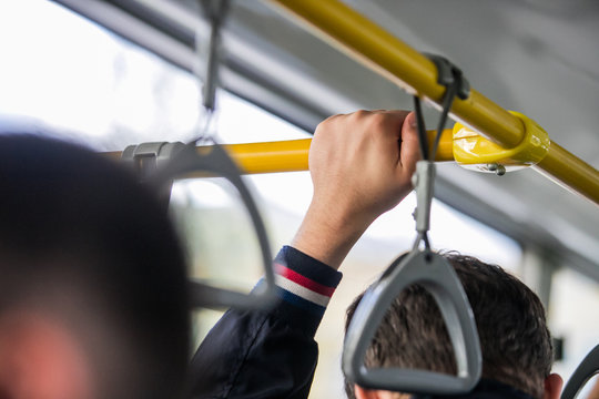 People Holding Onto A Handle On A Subway Train,Passenger Standing In Public Transportation. Person Commuting. Commuter Going To Work.