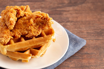 Pile of Chicken and Waffles on a Rustic Wooden Counter