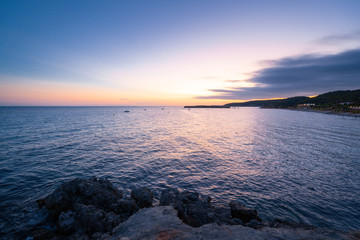 Beach of Sant Tomas on the island of Menorca during sunset. Mediterranean sea in spanish island.