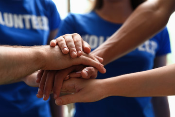Group of volunteers joining hands together, closeup