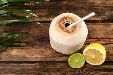 Open fresh coconut and citrus fruits on wooden table, above view